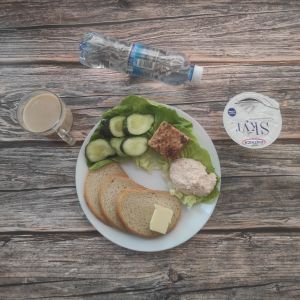 Zdjęcie przedstawia Dietę z ograniczeniem łatwo przyswajalnych węglowodanów: Masło extra Szynka Piastowska Ogórek świeży Kawa zbożowa z mlekiem Chleb Graham Jogurt typu islandzkiego naturalny Skyr Woda mineralna Sałata zielona Twarożek pomidorowy